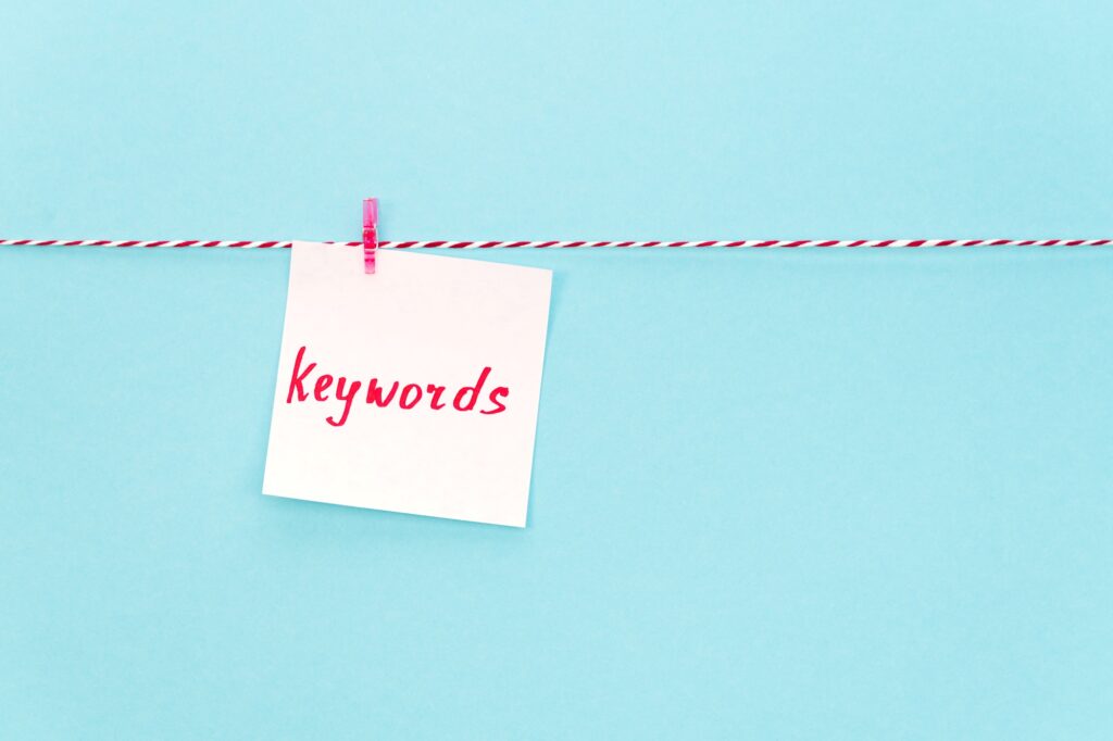 Note written on a white sticker that hangs with a clothespin on a rope on a blue color background.